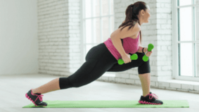 The girl is doing exercise with dumbbells